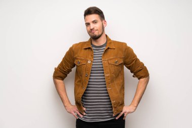 Silah, kalça ile poz ve gülümseyen beyaz duvar yakışıklı adam