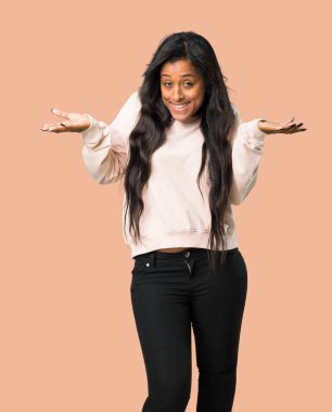 Genç afro Amerikalı kadın omuz izole kahverengi zemin üzerinde kaldırma sırasında önemli jest yapma