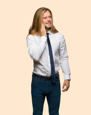 İzole arka plan üzerinde diş ağrısı ile uzun saçlı sarışın iş adamı