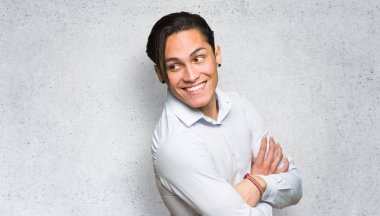 Yakışıklı adam dokulu duvar arka planda bir gülümseme ile omuz üzerinden bakıyor