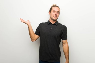 Beyaz boşaltmak hayali avuç içinde tutarak duvarın üzerinden uzun saçlı sarışın adam bir reklam eklemek için