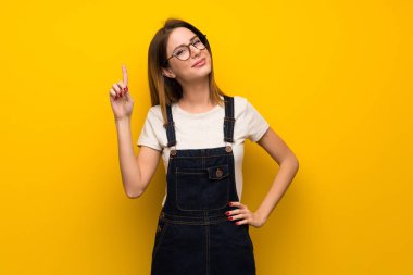 Kadın gösteren ve en iyi iz içinde parmak kaldırma sarı duvarın üzerinden