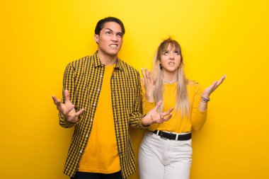 Canlı sarı arka plan üzerinde Genç çift kötü bir durum tarafından sinirli