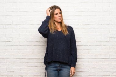 Sarışın kadın ile karıştırmayın yüz ifadesi ısırıkları dudak iken tuğla duvarın üzerinden