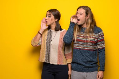 Hippi çift ağız geniş bağırarak sarı arka plan üzerinde lateral için açın