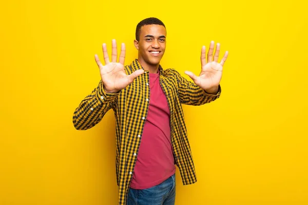 本の指で数える黄色背景に若いアフロ アメリカ人 — ストック写真
