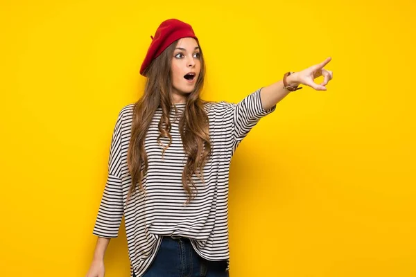 Chica Con Estilo Francés Sobre Pared Amarilla Apuntando Hacia Fuera — Foto de Stock