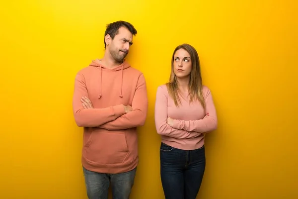 Group of two people on yellow background feeling upset