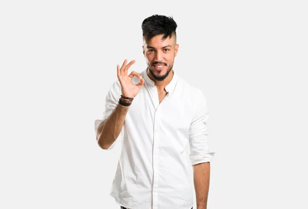 アラビア語の若いです男とともに白いシャツショーA Signとともに指で灰色の背景 — ストック写真