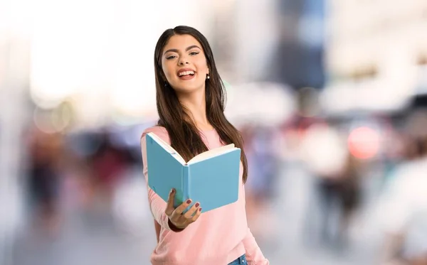 Teenager Mädchen Mit Rosa Hemd Hält Ein Buch Der Hand — Stockfoto