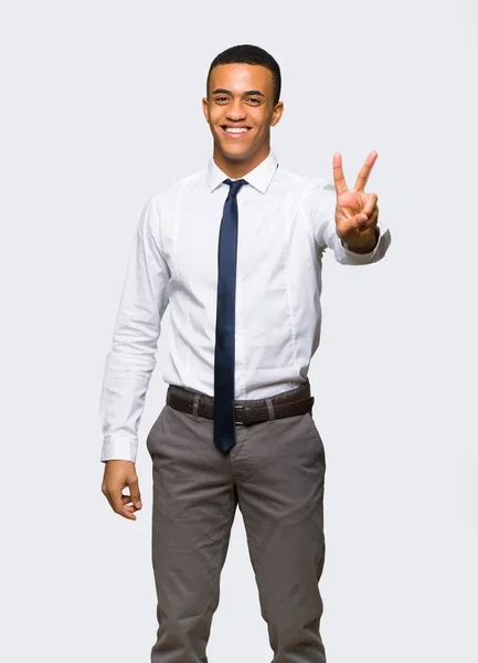 笑みを浮かべて 孤立した背景に勝利のサインを示す若いのアフロのアメリカのビジネスマン — ストック写真
