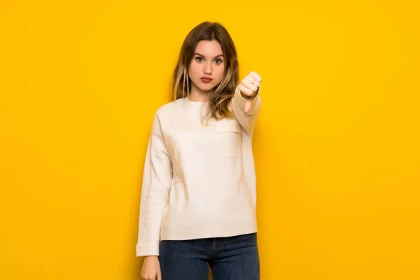 Dospívající Dívka Nad Žluté Zdi Ukazuje Palec Dolů Cedulka Negativní — Stock fotografie