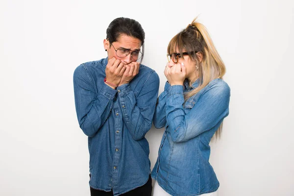 带眼镜的年轻夫妇有点紧张 害怕把手伸到嘴边 — 图库照片