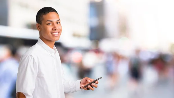 Joven Afroamericano Con Camisa Blanca Mirando Cámara Sonriendo Mientras Usa — Foto de Stock