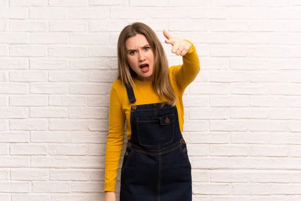 Adolescente Menina Sobre Parede Tijolo Branco Frustrado Apontando Para Frente — Fotografia de Stock