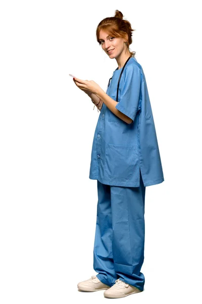 Full Length Shot Young Redhead Nurse Sending Message Mobile Isolated — Stock Photo, Image