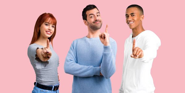 Group of three friends counting number one sign