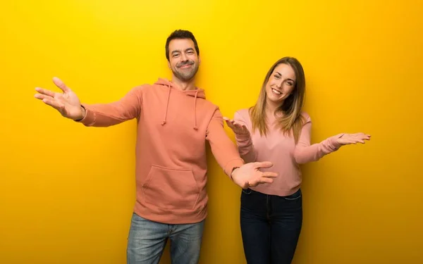 Grupo Duas Pessoas Fundo Amarelo Apresentando Convidando Para Vir Com — Fotografia de Stock