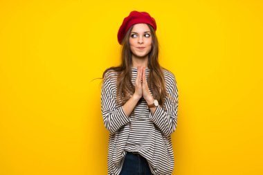 Girl with french style over yellow wall scheming something clipart