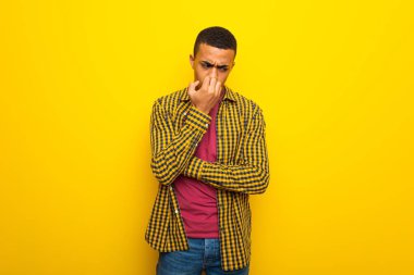 Genç afro Amerikalı adam sarı arka plan şüpheleri üzerinde