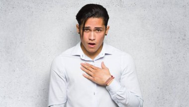 Yakışıklı adam dokulu duvar arka plan sağ bakarken şaşırttı ve şok