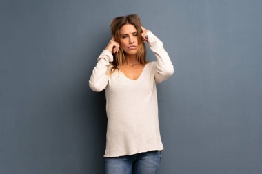 Şüpheleri ve düşünme gri arka plan üzerinde sarışın kadın