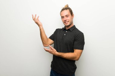 Beyaz duvar uzanan üzerinde uzun saçlı sarışın adam yanına gelmek için davet için eller