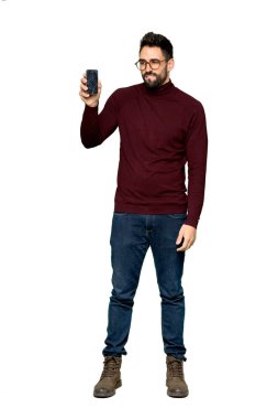 Sorunlu holding smartphone izole beyaz arka plan üzerinde kırık ile gözlüklü yakışıklı adam tam uzunlukta atış