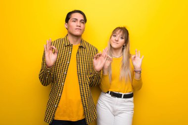 Zen poz canlı sarı arka plan üzerinde genç çift