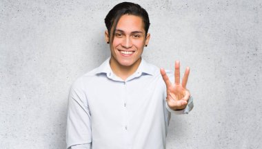 Yakışıklı adam mutlu ve dokulu duvar arka plan parmakları ile üç sayma