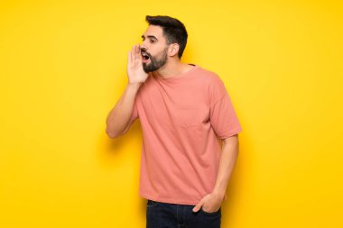 Lateral için açık ağızlı bağırmayı sarı duvarın üzerinden yakışıklı adam