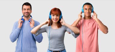 Grup üç arkadaşıyla birlikte kulaklık ile müzik dinlemek