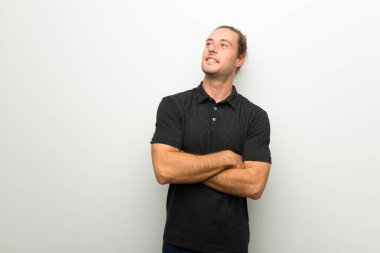 Beyaz duvar gülümseyen süre seyir üzerinde uzun saçlı sarışın adam