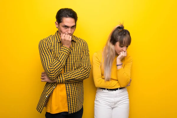 Junges Paar Vor Leuchtend Gelbem Hintergrund Hat Zweifel — Stockfoto