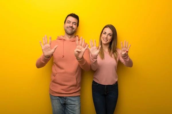 Grupp Två Människor Gul Bakgrund Räknar Nio Med Fingrar — Stockfoto