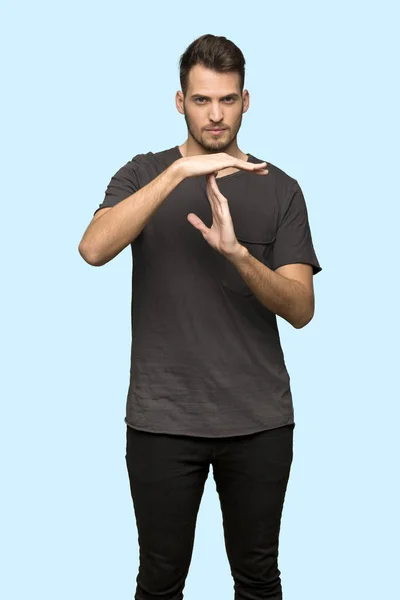 Mężczyzna Czarną Koszulę Podejmowania Gest Limit Czasu Niebieskim Tle — Zdjęcie stockowe