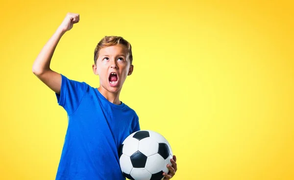 Gelukkige Jongen Voetballen Gele Achtergrond — Stockfoto