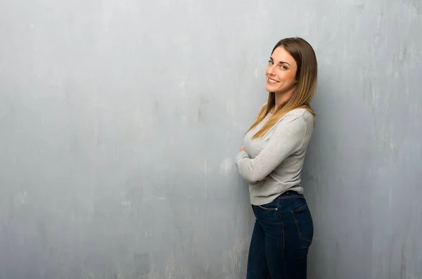 Młoda Kobieta Teksturą Ściany Utrzymując Ramiona Skrzyżowanymi Pozycji Bocznej Jednocześnie — Zdjęcie stockowe