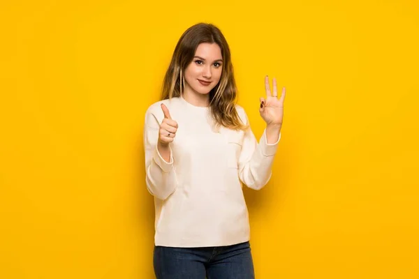 Adolescente Chica Sobre Amarillo Pared Mostrando Signo Con Dando Pulgar —  Fotos de Stock