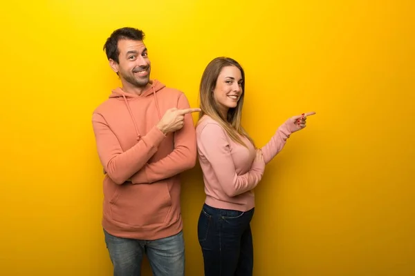 Група Двох Людей Жовтому Тлі Вказуючи Пальцем Бік Боковому Положенні — стокове фото