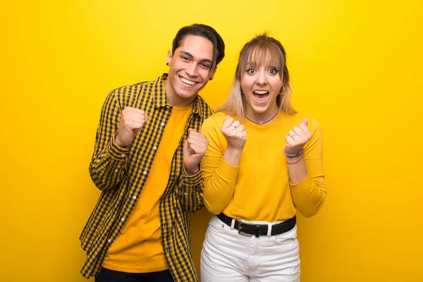 Junges Paar Vor Leuchtend Gelbem Hintergrund Feiert Einen Sieg Der — Stockfoto