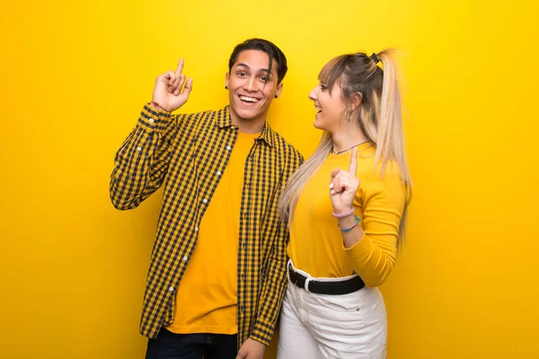 Junges Paar Vor Leuchtend Gelbem Hintergrund Das Die Lösung Erkennt — Stockfoto