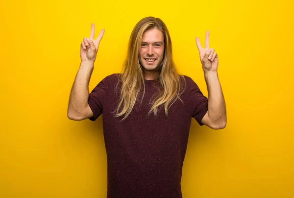 Blondyn Długie Włosy Nad Żółte Ściany Uśmiechając Się Pokazuje Znak — Zdjęcie stockowe