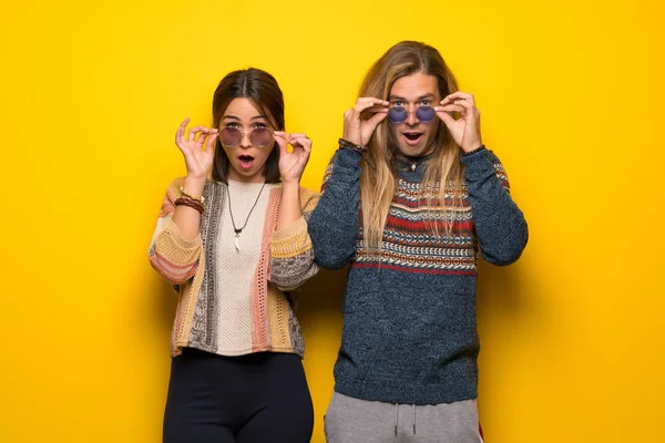 Hippie Pareja Sobre Fondo Amarillo Con Gafas Sorprendido — Foto de Stock
