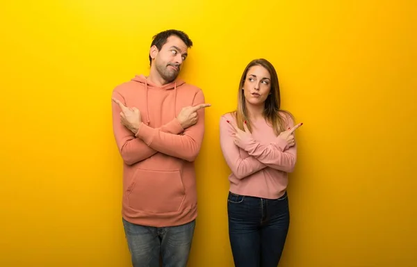 Grupo Dos Personas Sobre Fondo Amarillo Apuntando Los Laterales Que — Foto de Stock