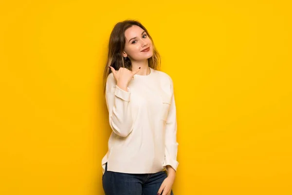 Nastolatek Dziewczyna Nad Żółte Ściany Telefon Gest Zadzwoń Mnie Znak — Zdjęcie stockowe