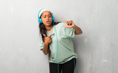 Genç afro Amerikalı kadın kulaklık ile müzik ve dans dokulu arka plan üzerinde