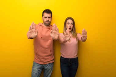 Grup dur jest yapmak için sarı zemin üzerine iki insan bir görüş ile hayal kırıklığına