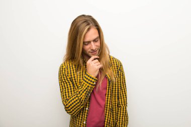 Sarışın adam uzun saçlı ve kareli gömlek çene üzerinde el ile bakıyor