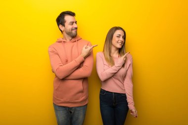 Bir grup insan bir ürün sunmak için iki tarafına işaret Sarı zemin üzerine